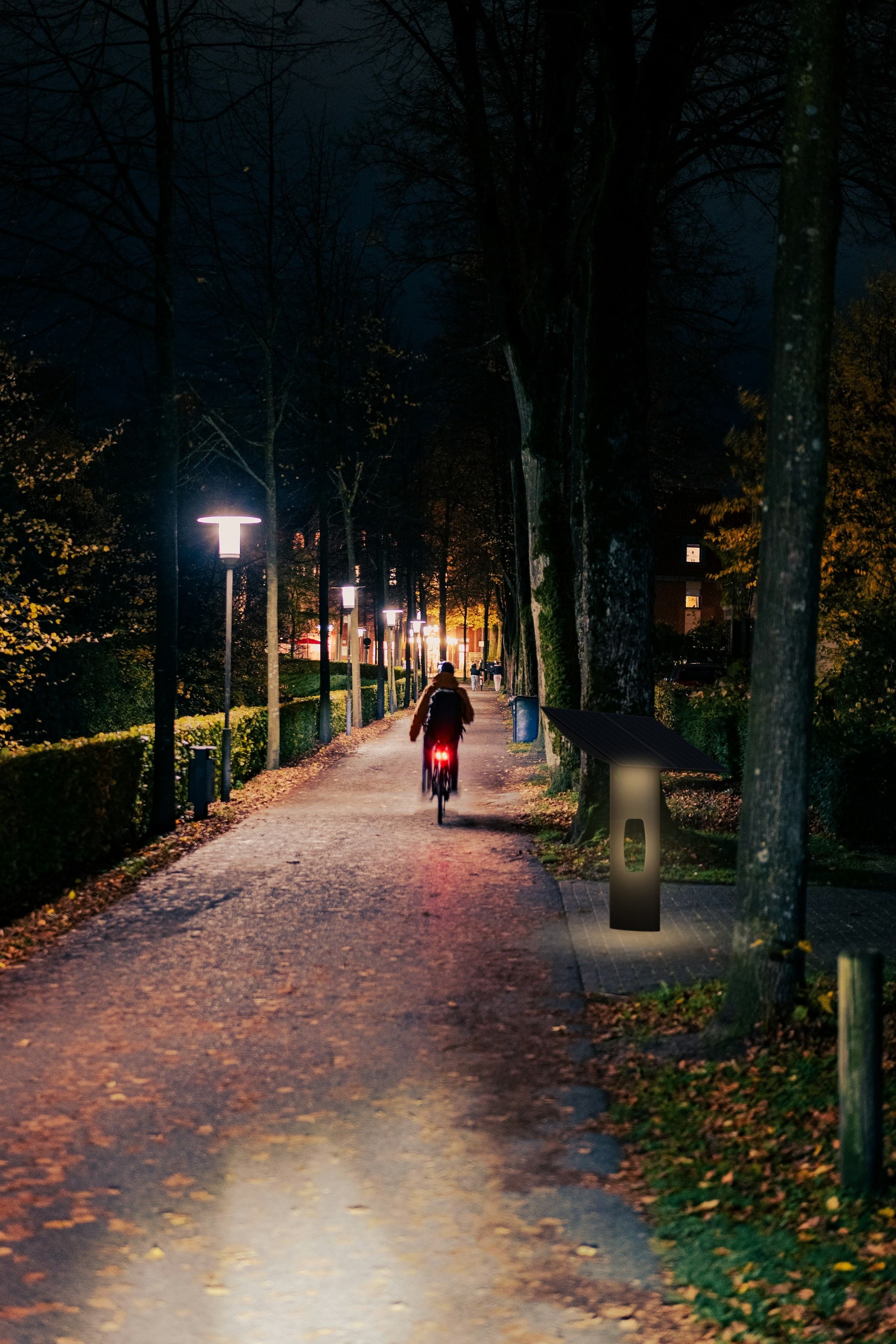 Microgen photovoltaic shelter in the evening along a tree-lined path, with its light on